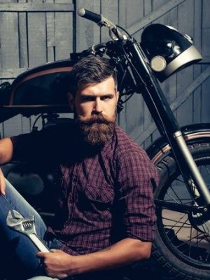 67565029-bearded-man-hipster-biker-brutal-male-with-beard-and-moustache-in-leather-jacket-sits-on-floor-near-.jpg